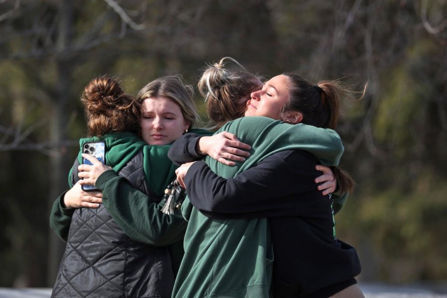 Students at Michigan State comfort each other after a mass shooting on their campus. 