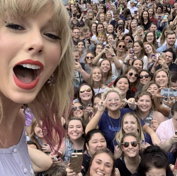 Taylor Swift takes a selfie with fans during her Eras Tour