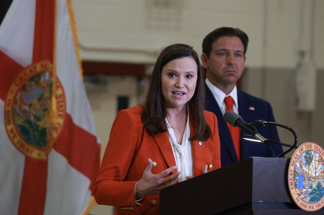 Florida's Attorney General, Ashley Moody speaking at a press conference with Governor Ron DeSantis.