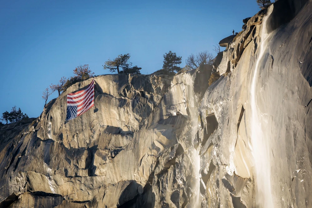 An upside-down U.S. flag hangs as a protest at Yosemite's El Capitan. An upside-down American flag is typically reserved as a sign of distress or extreme emergencies. 
