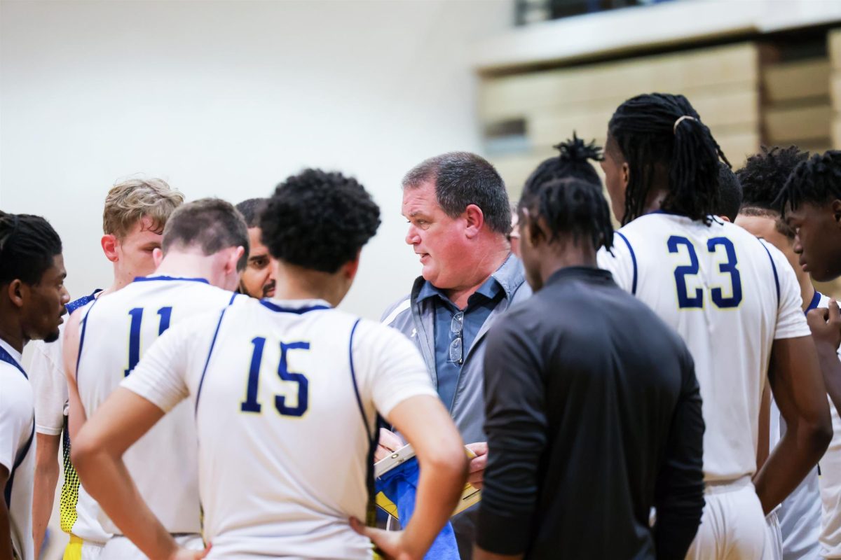 Coach Bailey pictured discussing strategy with the boys Varsity Basketball team.