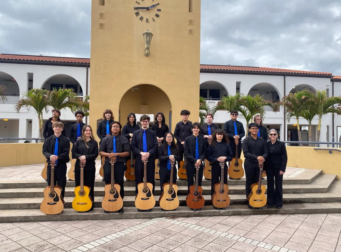 Students in the the UHS Guitar Magnet pose in front of the bell tower. 